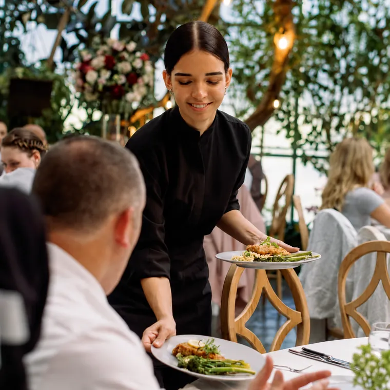 Uniformed server presenting a dish